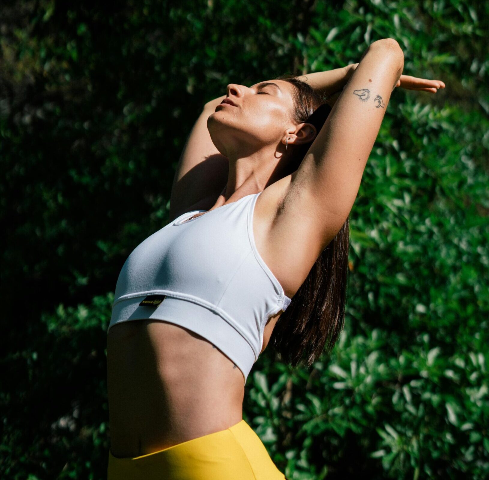 A woman in a yoga pose outdoors, symbolizing a healthy lifestyle and mindfulness.